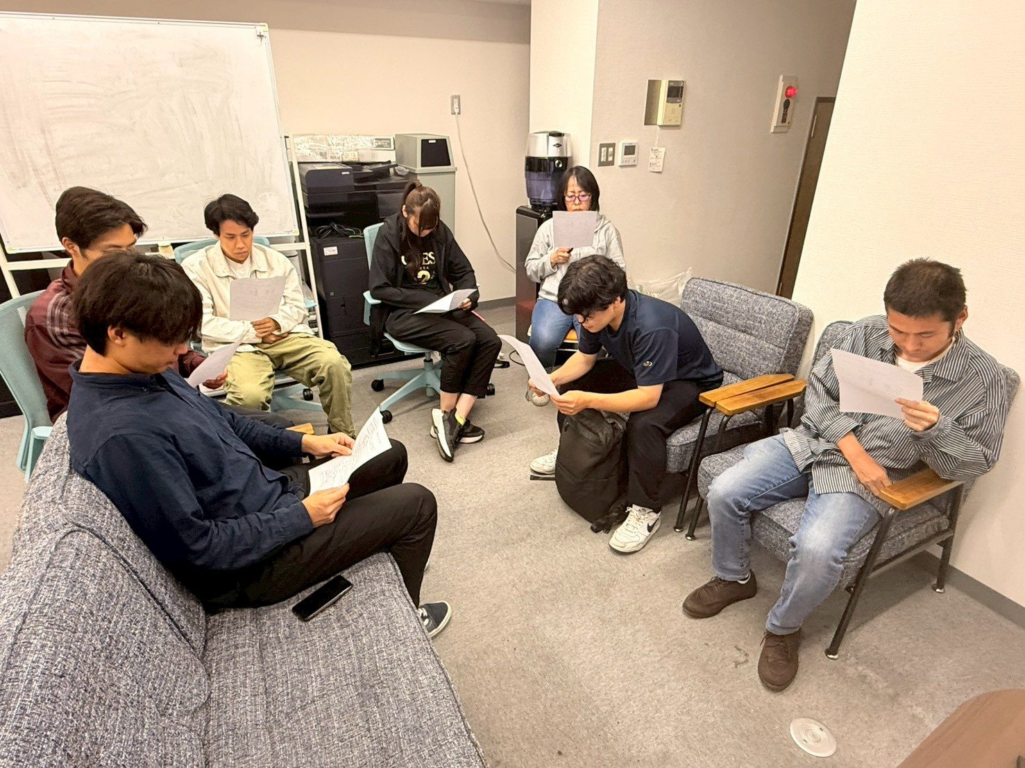 オフィスで資料を読み合わせるスタッフたち